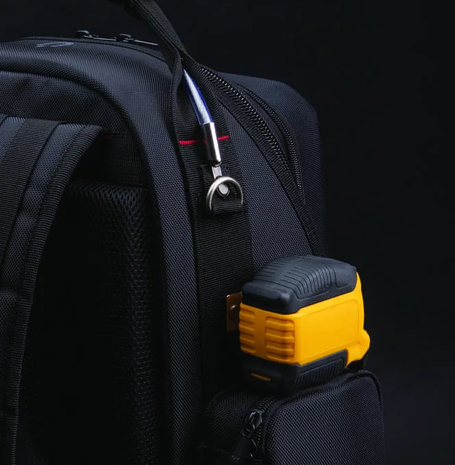 A yellow tape measure clipped to the external tool clip on the side of the 3996, next to the D-ring.