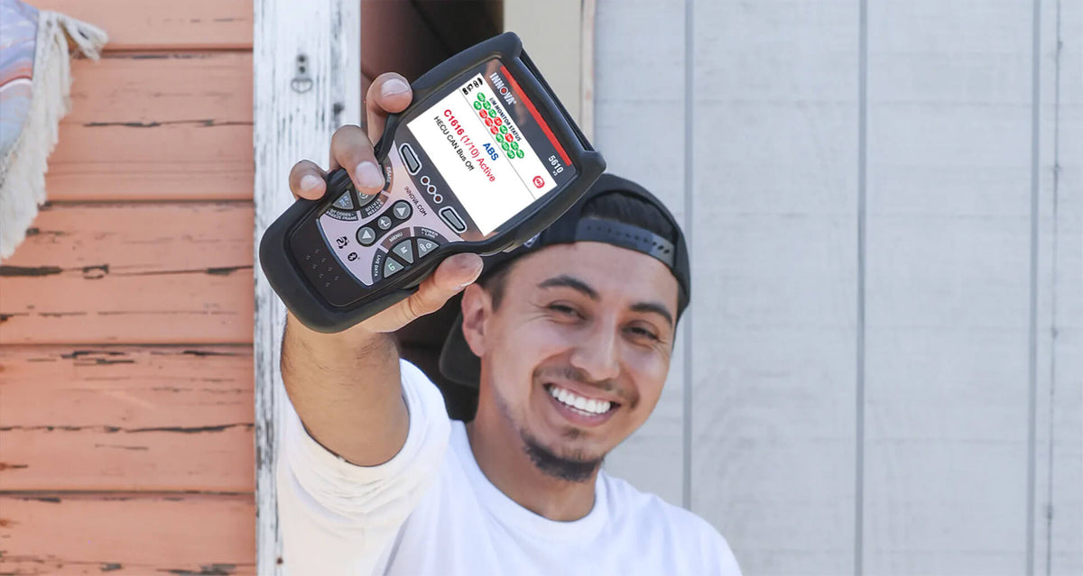 A smiling DIYer holding up an Innova 5610 scanner.