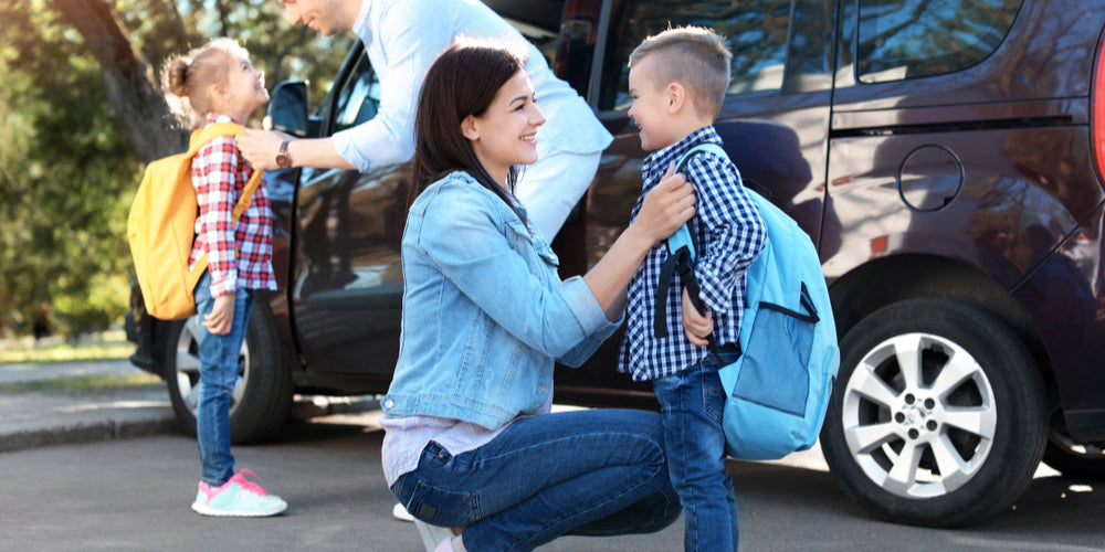 Family of four getting their kids ready for a road trip