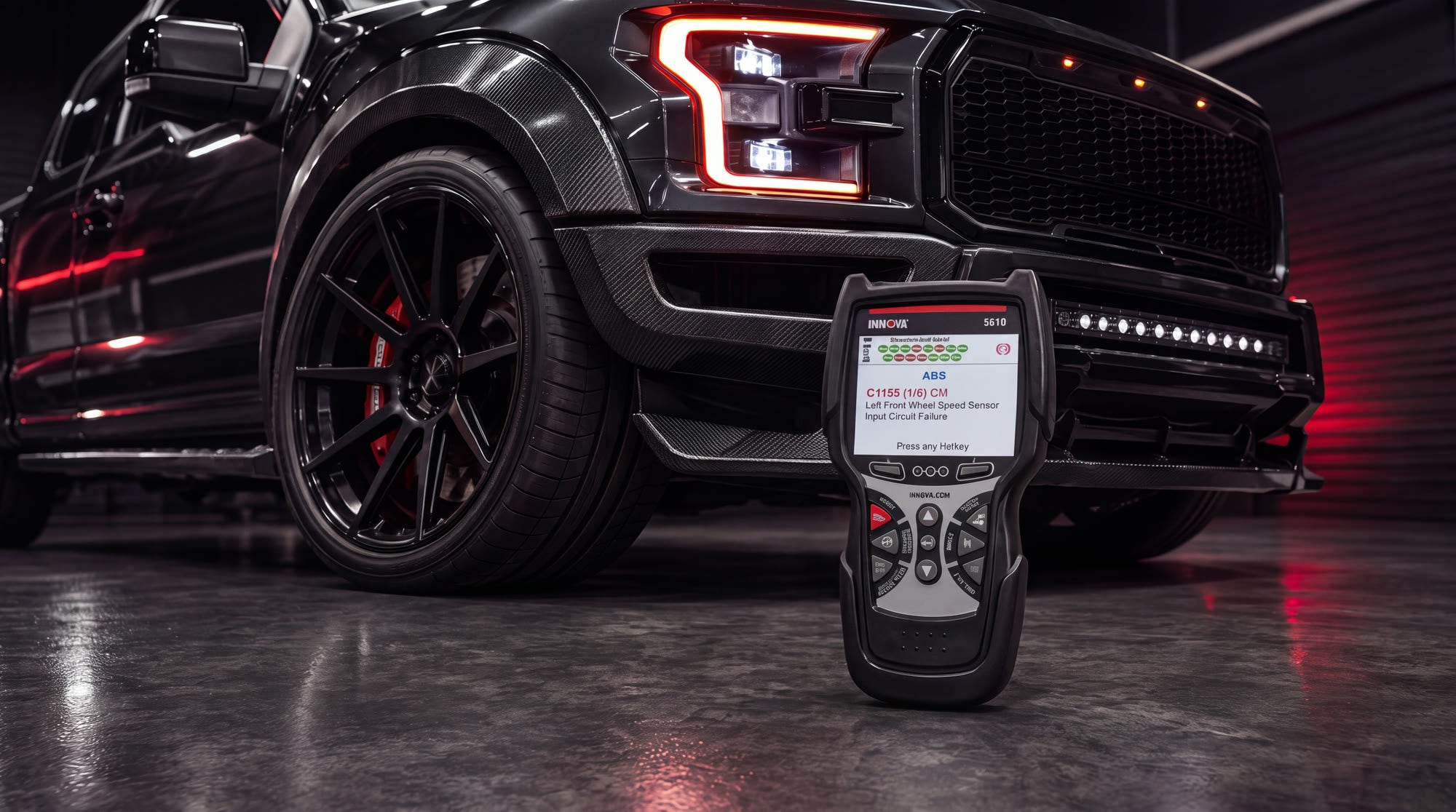 Modified black pickup truck in a dark garage with the Innova 5610 scanner