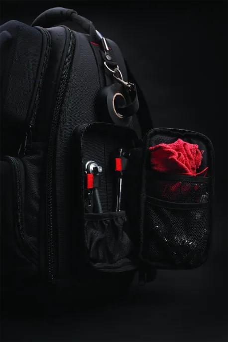 The right side compartment open, holding two ratchets and a mesh pocket with a red shop rag.