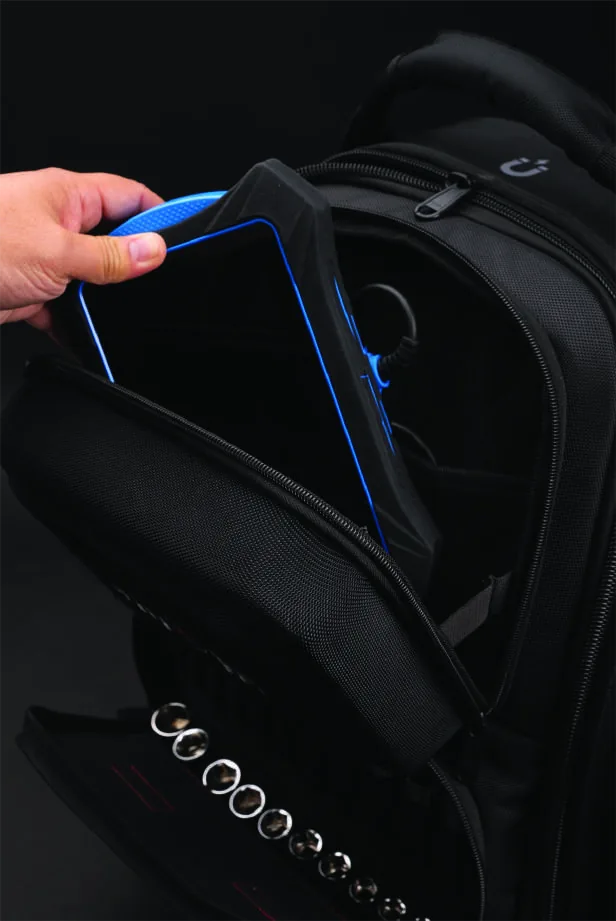 A hand sliding a blue Innova diagnostic tablet into the padded top compartment of the 3996.
