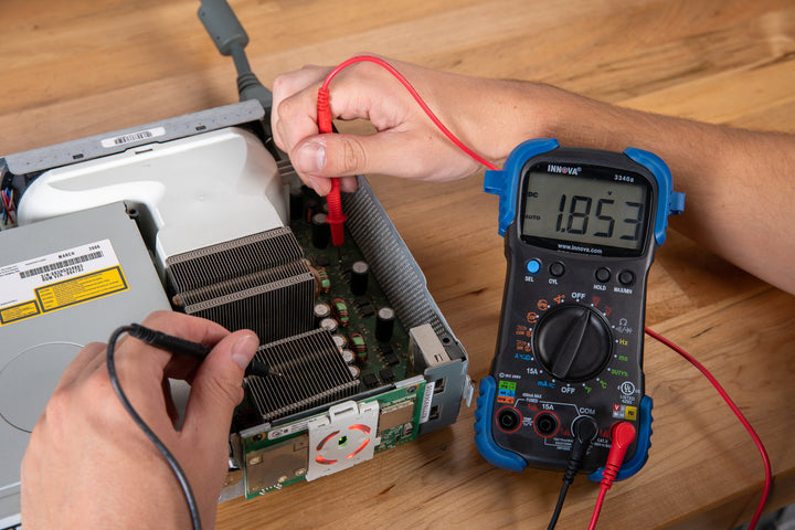 Innova Electronics 3340 digital multimeter checking voltage on a computer board